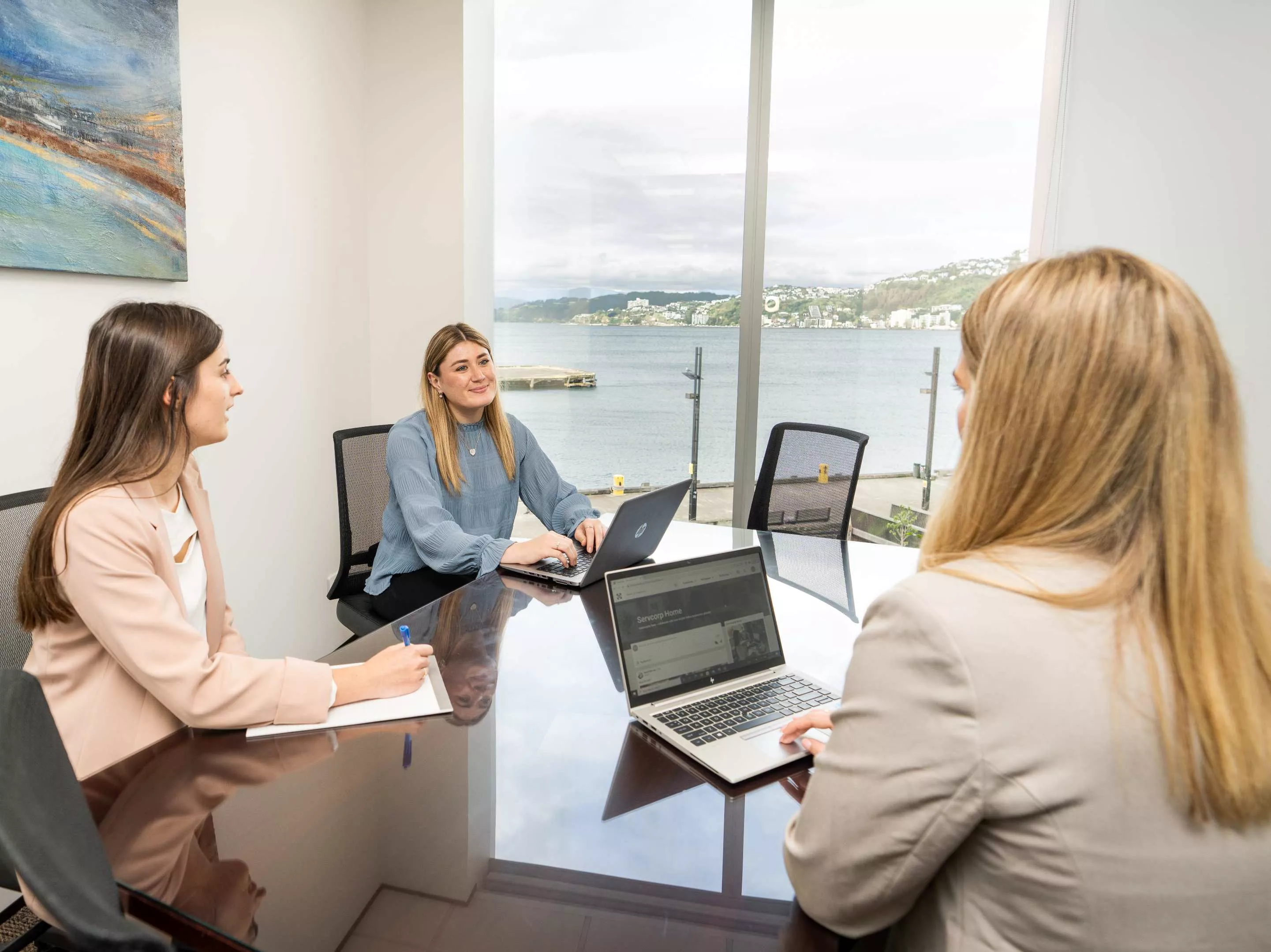 A client talking to her clients working in a modern meeting room space in Servcorp Bell Gully Building, Wellington